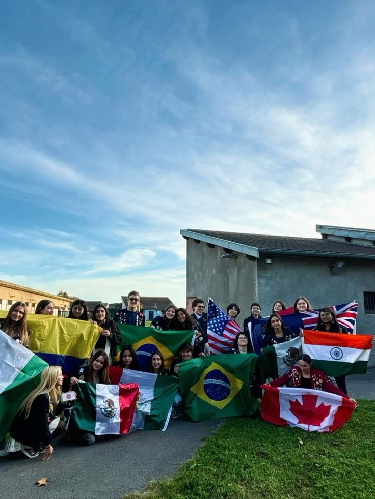 Grupo de jovens intercambistas segurando bandeiras de vários países