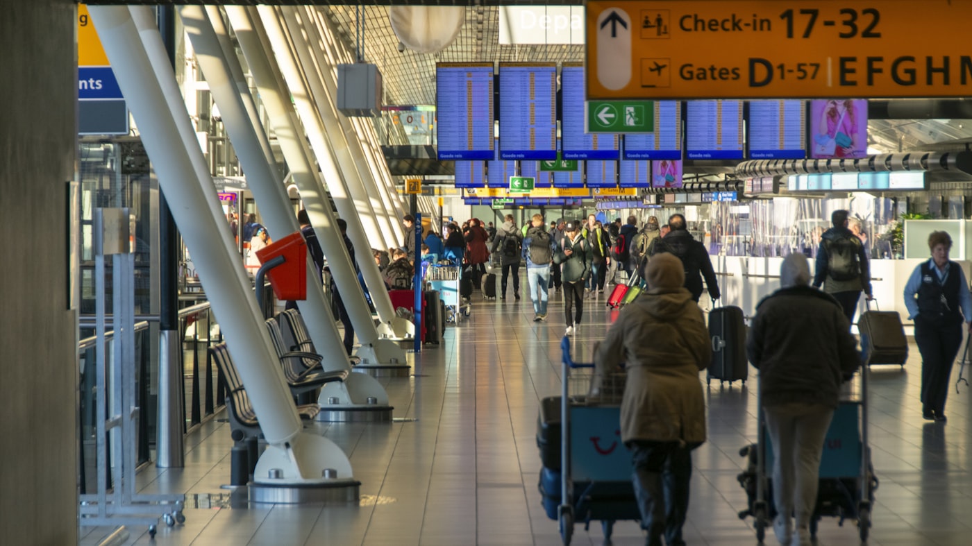 Viajantes com bagagem no saguão de embarque de um aeroporto